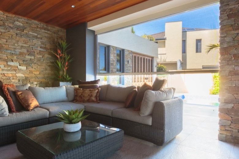 Customer's alfresco area before — open span between stone pillars with outdoor lounge