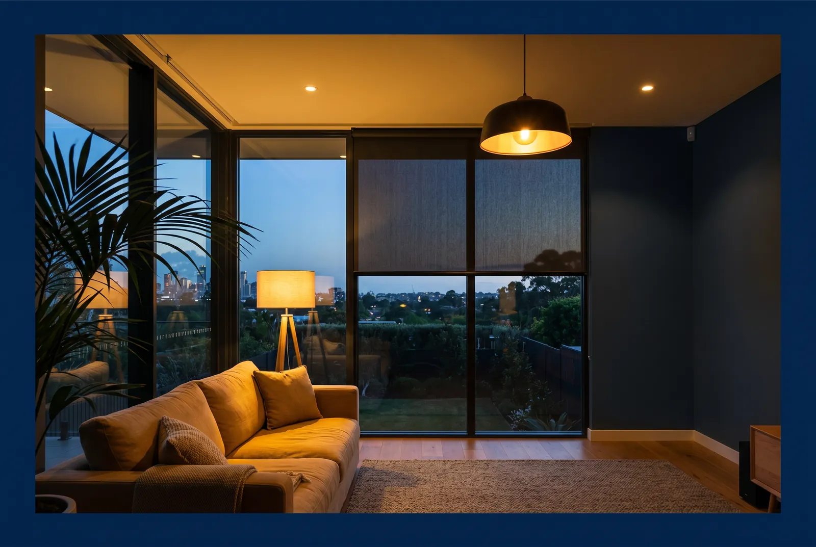 Motorised sunscreen roller blind in a contemporary Australian living room at dusk — Rollease Acmeda motorised internal blind by Vivanova.